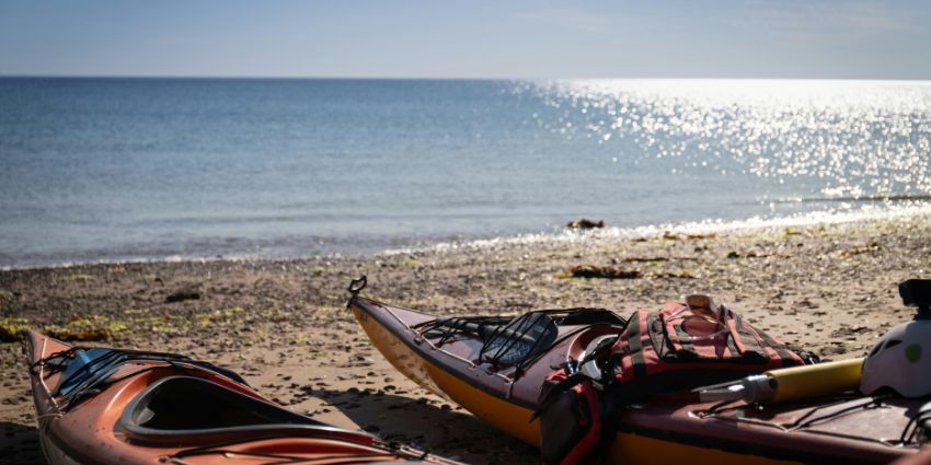 Kayaks resting on a sunlit beach ready for an exciting coastal adventure.
