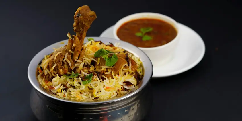 Flavorful chicken biryani served with curry, a popular traditional dish.
