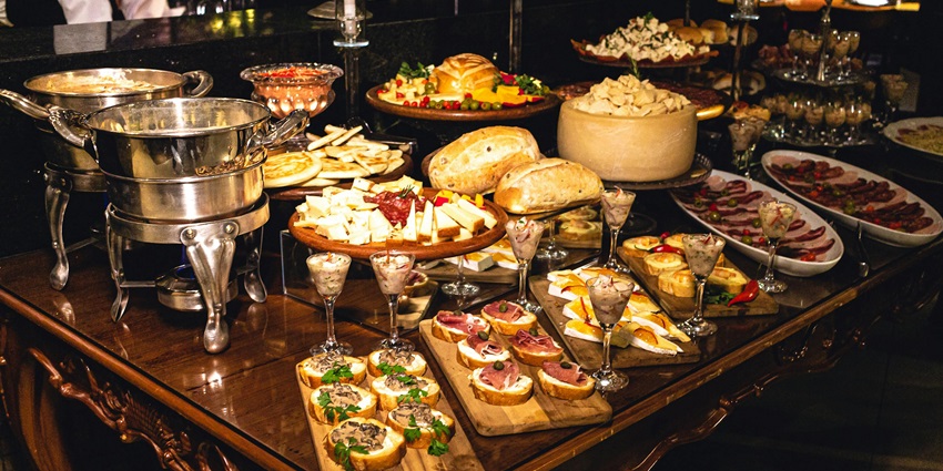 A lavish spread of Brazilian cuisine featuring bread, cheese, meats, and appetizers.