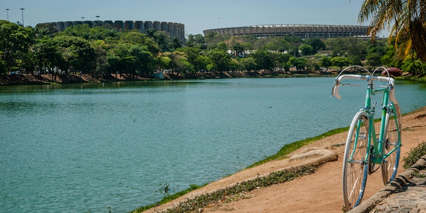 A peaceful waterfront with a bicycle and stadiums in the background in Brazil.