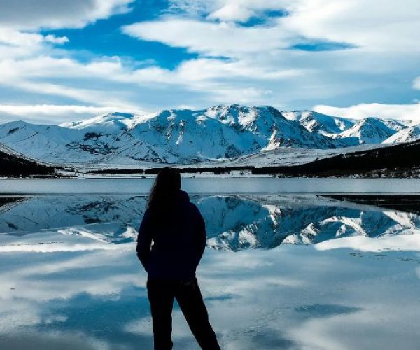 A breathtaking view of Argentina’s snowy peaks mirrored in a tranquil lake.